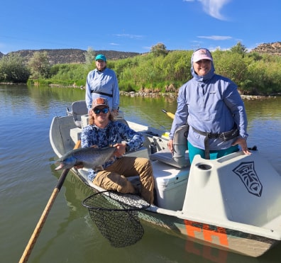 Fishing guide and guests in drift boat