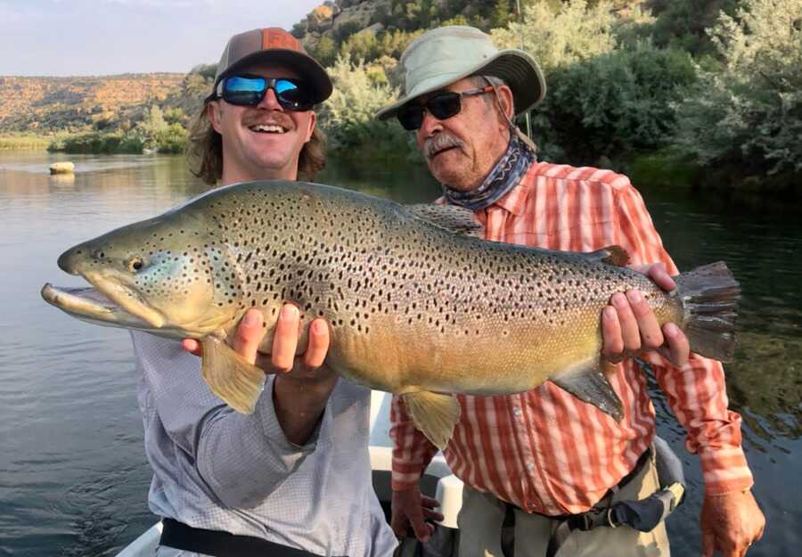 Fly angler holding a large brown trout on the San Juan River