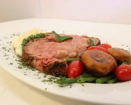 Plated prime rib with side of green beans and mushrooms