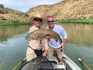 Customer in drift boat with trout