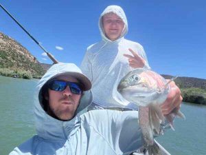 Fly fishing guide and teen wiht rainbow trout
